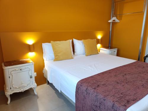 a bedroom with a large white bed with yellow walls at B&B Sbarco dei 1000 Marsala in Marsala