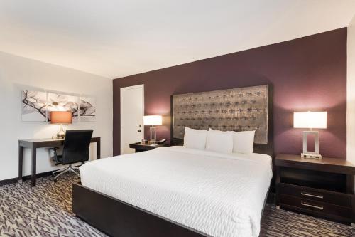 a hotel room with a large bed and a desk at Clarion Inn & Suites Across From Universal Orlando Resort in Orlando