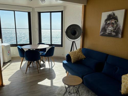 un soggiorno con un divano blu e un tavolo di Appartement moderne vue sur étang et montagne a Le Barcarès