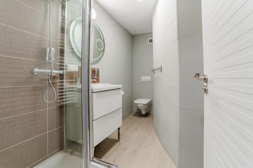 a bathroom with a shower and a sink and a mirror at Romantic Jacuzzi Luxury Apartment in Sinaia