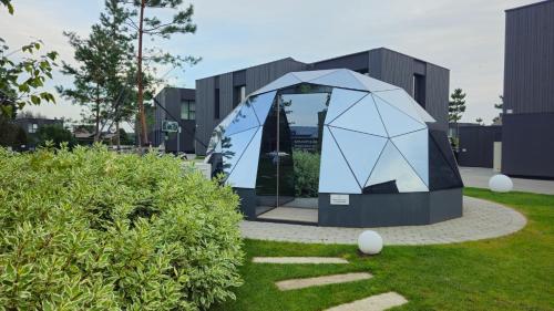 a building with a dome in the grass at SMĖLĖTOS KOPOS - Mano jūra 3 in Kunigiškiai