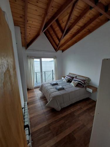 a bedroom with a large bed and a large window at Departamento Ushuaia in Ushuaia