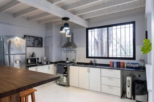 a kitchen with white cabinets and a large window at Monica’s Apartments in Canning