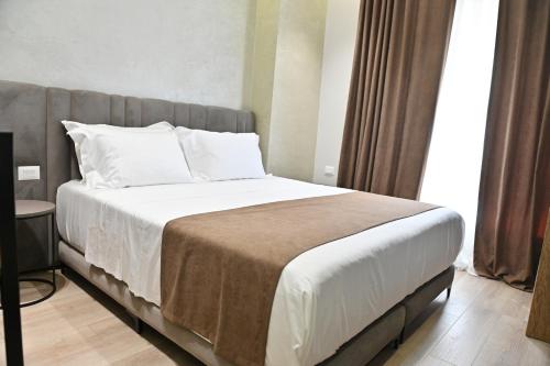 a bedroom with a large bed with white sheets and pillows at Galeria's Rooms, Central Tirana, Self Check-In in Tirana
