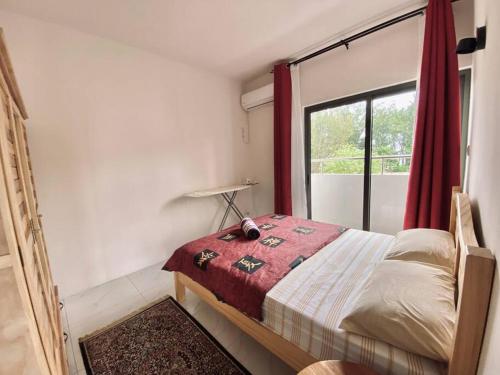 a small bedroom with a bed with a window at 3-Bedroom Apt with Oceanviews, 1min Walk to Beach - NYHA2 in Flic-en-Flac