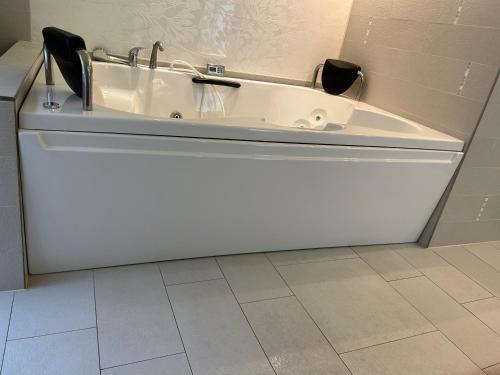 a bath tub with two chairs in a bathroom at Bástya Konferencia és Wellness Hotel in Miskolctapolca