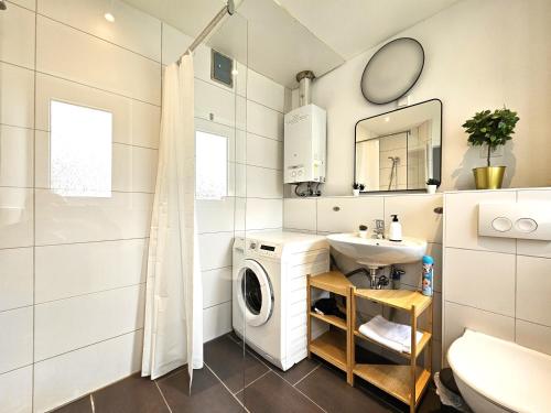 a bathroom with a washing machine and a sink at Spacious House in Düsseldorf