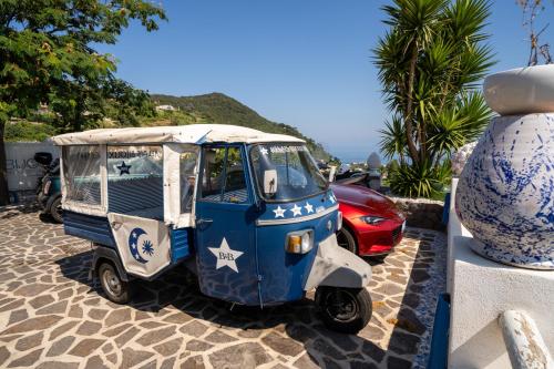 a small blue and white car parked on a sidewalk at Relais Bijoux Ischia in Ischia