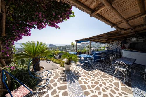a patio with a table and chairs and plants at Relais Bijoux Ischia in Ischia