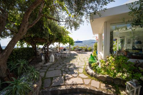 a walkway in front of a building with trees at Relais Bijoux Ischia in Ischia