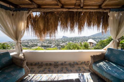 a balcony with two chairs and a view of the city at Relais Bijoux Ischia in Ischia