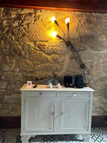 a white cabinet against a wall with a stone wall at Casa de Costoia in Santiago de Compostela