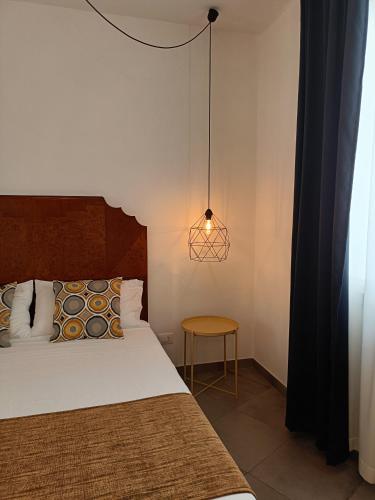 a bedroom with a bed and a lamp and a table at Anita & Garibaldi in Marsala