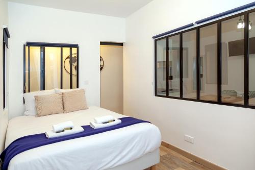 une chambre avec un grand lit blanc avec une fenêtre dans l'établissement Nets Inn Apartments - Voltaire, à Paris