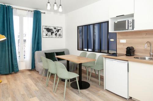 une cuisine et une salle à manger avec une table et des chaises dans l'établissement Nets Inn Apartments - Voltaire, à Paris