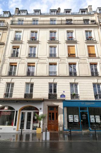 un grand bâtiment blanc dans une rue de la ville dans l'établissement Nets Inn Apartments - Voltaire, à Paris