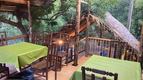 a room with a table and chairs and a tree at Ceylon Beach haven Uppuveli in Trincomalee