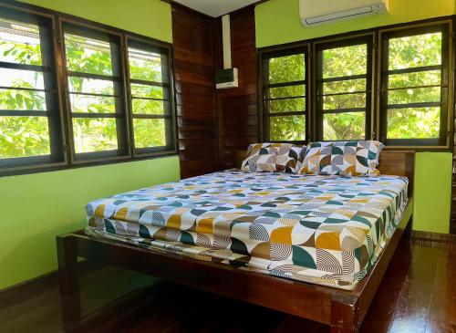 a bedroom with a bed in a room with windows at Croc Camp in Lat Krabang