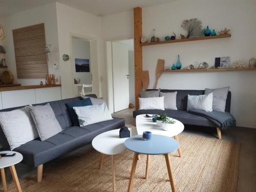 a living room with a blue couch and two tables at Ferienhof Elbauenblick in Radebeul