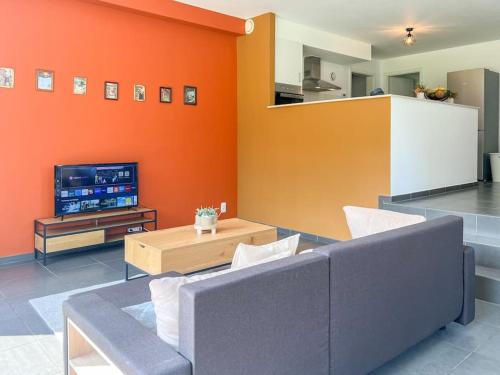 a living room with a couch and a tv at Charmant Logement Brugelette Proche de Pairi Daiza in Brugelette
