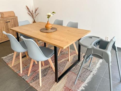 a wooden table with gray chairs and a vase on it at Charmant Logement Brugelette Proche de Pairi Daiza in Brugelette