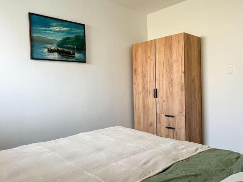 a bedroom with a bed and a wooden cabinet at Charmant Logement Brugelette Proche de Pairi Daiza in Brugelette