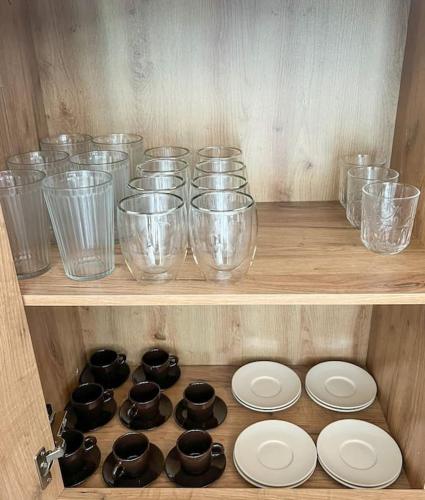 a wooden shelf with glass bowls and plates on it at Charmant Logement Brugelette Proche de Pairi Daiza in Brugelette