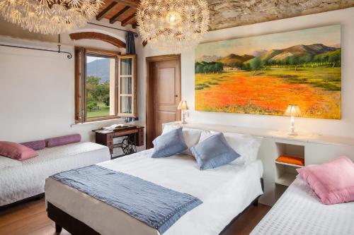 a bedroom with two beds and a painting on the wall at Olimagio Farm Stay with animals and 25m pool, beach at cycling distance in Pietrasanta