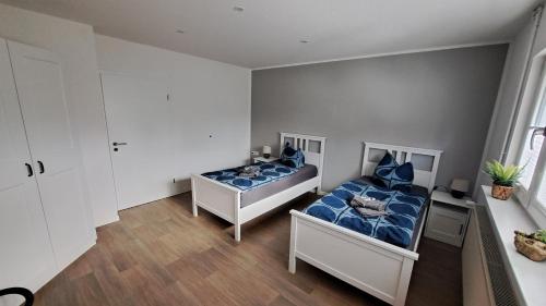 a bedroom with two beds with blue pillows at Gästehaus Ehrhardt in Merseburg