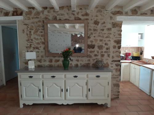 - une cuisine avec une armoire blanche et un miroir dans l'établissement petit gite l'ecotay, à Saint-Symphorien