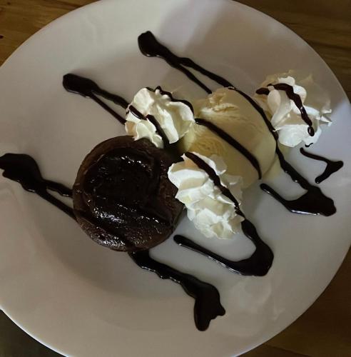 a chocolate dessert with ice cream on a white plate at Hotel Restaurant Edelweiss in Mühlen