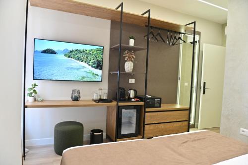 a bedroom with a bed with a tv on a wall at Galeria's Rooms, Central Tirana, Self Check-In in Tirana