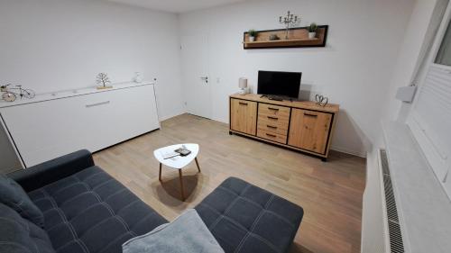 a living room with a couch and a tv at Gästehaus Ehrhardt in Merseburg
