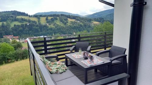 a table and chairs on a balcony with a view at Dom Camelowo Willa in Brenna