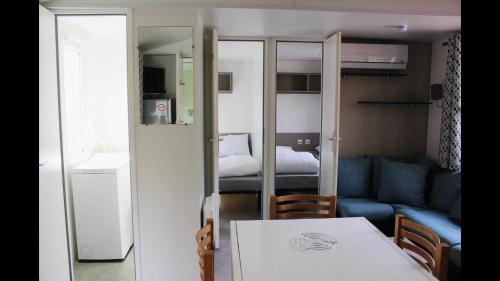ein kleines Wohnzimmer mit einer Couch und einem Tisch in der Unterkunft Bungalow Camping 4 à 8 personnes in Les Mathes