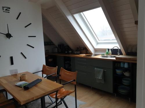 a kitchen with a table and a clock on the wall at Ferienhof Elbauenblick in Radebeul