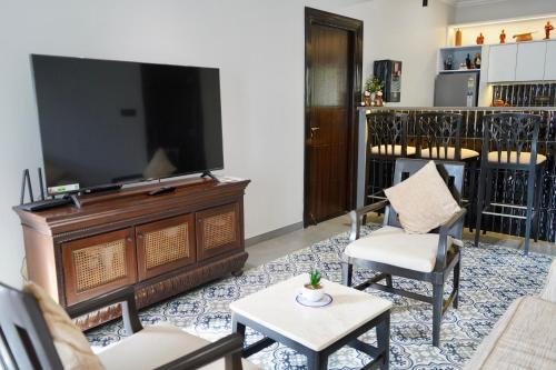 a living room with a flat screen tv and chairs at SeaBreezeMajorda in Majorda