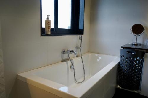 a bathroom with a bath tub with a shower at SeaBreezeMajorda in Majorda