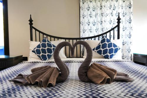 two towels in the shape of swans on a bed at SeaBreezeMajorda in Majorda