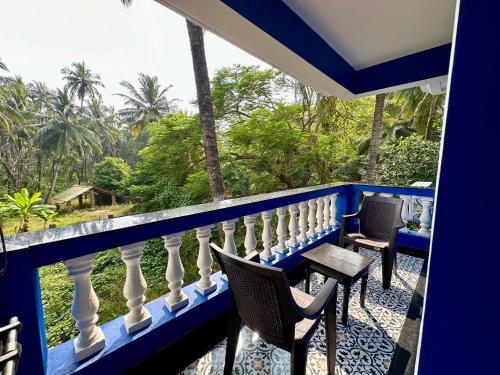 a balcony with chairs and a view of the jungle at SeaBreezeMajorda in Majorda