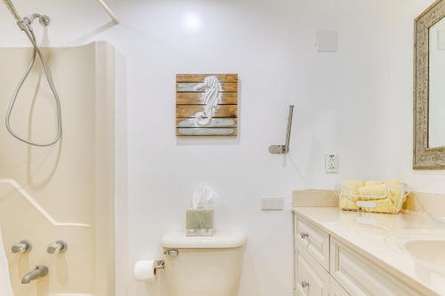 a white bathroom with a toilet and a sink at Oceanfront Atlantic Beach Condo with View! in Atlantic Beach