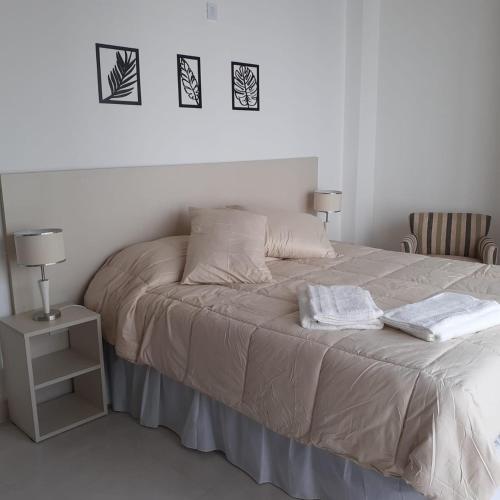 a bed with two towels on it in a bedroom at Monoambientes Magus in Junín