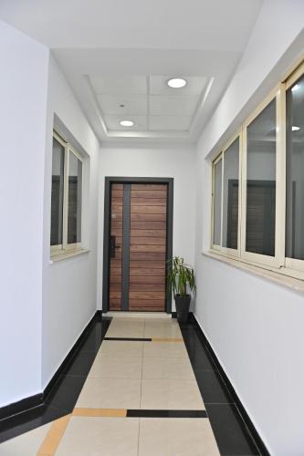 a hallway with white walls and a wooden door at Galeria's Rooms, Central Tirana, Self Check-In in Tirana