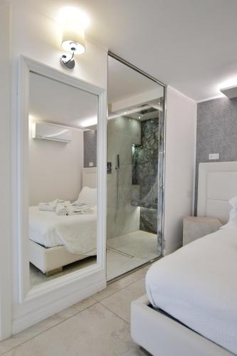 a white bedroom with a glass shower and a bed at Domus De Cinti in Tivoli