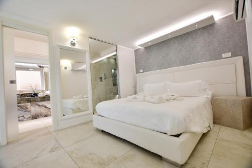 a bedroom with a white bed and a large mirror at Domus De Cinti in Tivoli