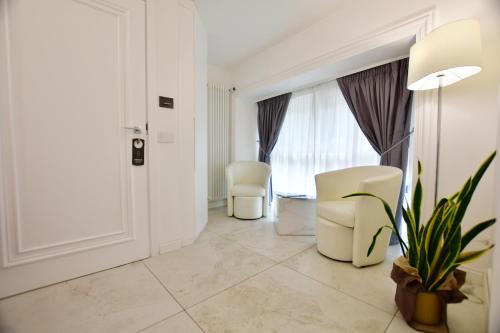 a living room with two white chairs and a window at Domus De Cinti in Tivoli