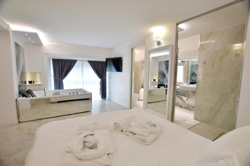 a white bedroom with towels on a bed and a bathroom at Domus De Cinti in Tivoli