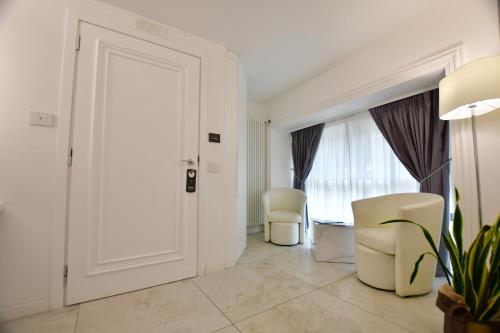 a white room with two chairs and a door at Domus De Cinti in Tivoli