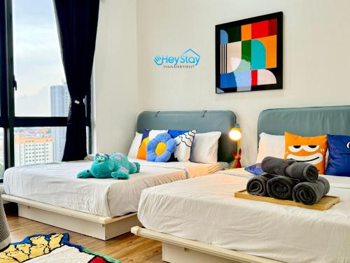 two beds with stuffed animals on them in a room at The Apple Residence By Heystay Management in Melaka