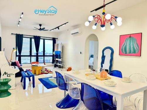a living room with a white table and blue chairs at The Apple Residence By Heystay Management in Melaka